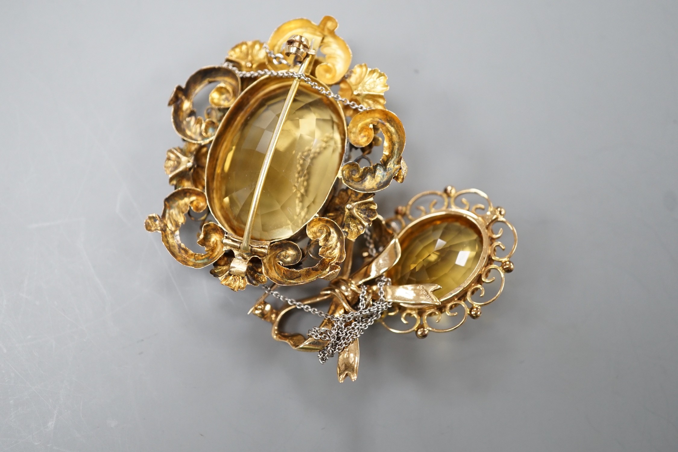 A late Victorian yellow metal and oval cut citrine set brooch, 49mm and a modern 9ct gold and oval cut citrine set drop brooch, gross 12 grams.